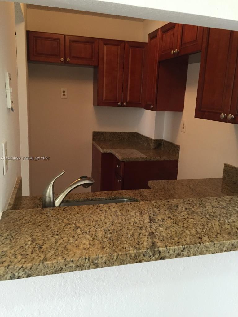 8145 Northwest 7th Street, Unit 406 Miami, FL 33126 - Photo 1 of 9 a kitchen with wooden cabinets
