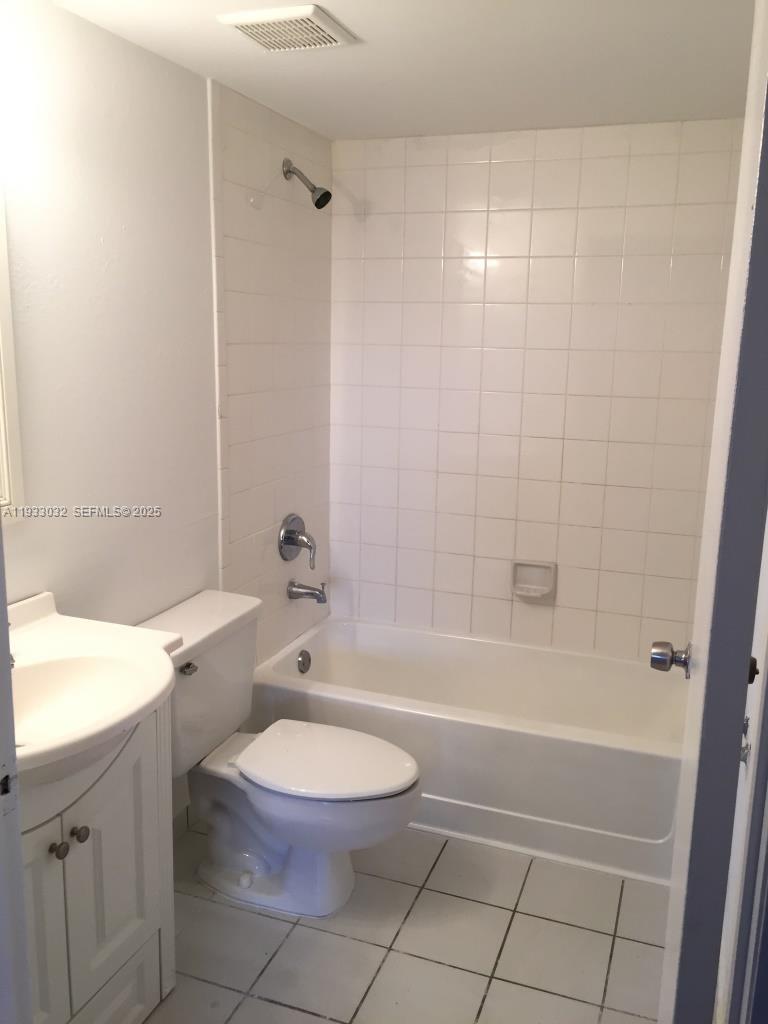 8145 Northwest 7th Street, Unit 406 Miami, FL 33126 - Photo 6 of 9 a bathroom with a bathtub shower sink vanity and a toilet