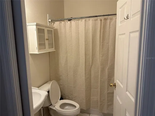 a white toilet sitting next to a shower curtain