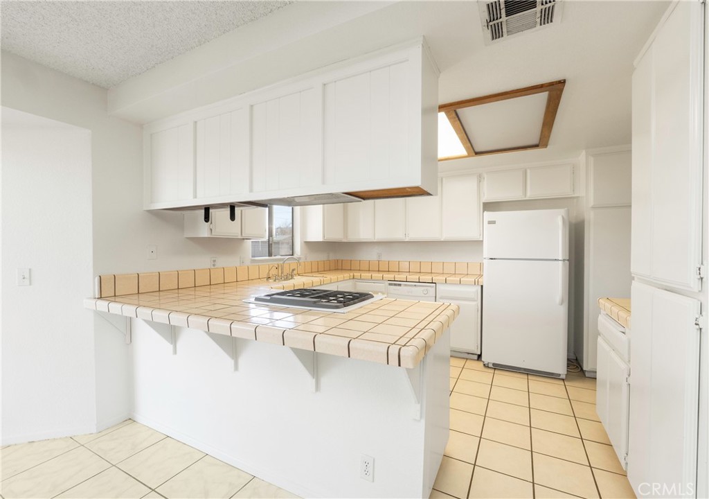 11135 Truchas Road Apple Valley, CA 92308 - Photo 10 of 35 a kitchen with a stove a refrigerator and cabinets