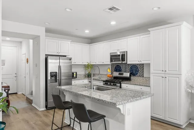 a kitchen with stainless steel appliances granite countertop a refrigerator stove microwave and sink