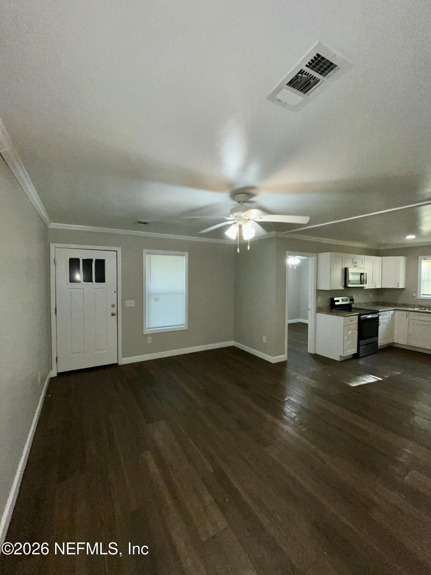 2017 Talladega Road Jacksonville, FL 32209 - Photo 12 of 34 an empty room with wooden floor cabinet and windows