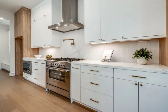a kitchen with white cabinets and appliances