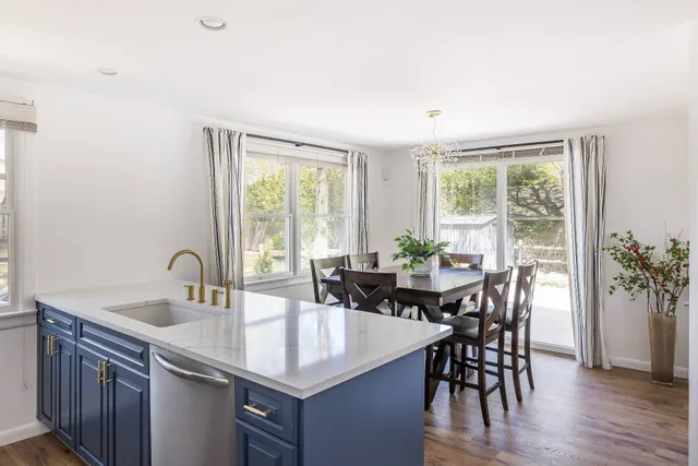 a kitchen with a table chairs and wooden floor