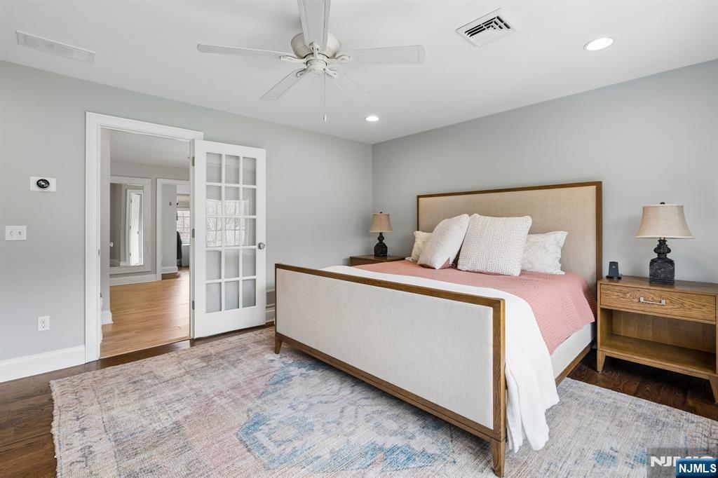 44 Millbrook Road New Vernon, NJ 07976 - Photo 22 of 45 a spacious bedroom with a large bed and a chandelier