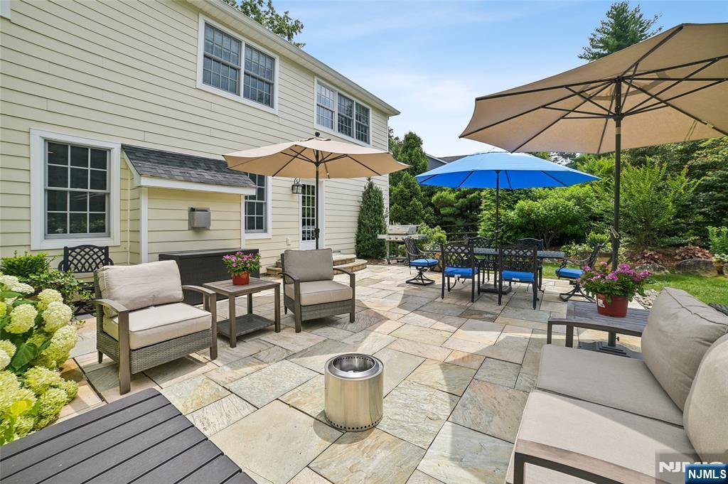 44 Millbrook Road New Vernon, NJ 07976 - Photo 39 of 45 a patio with patio a table and chairs under an umbrella