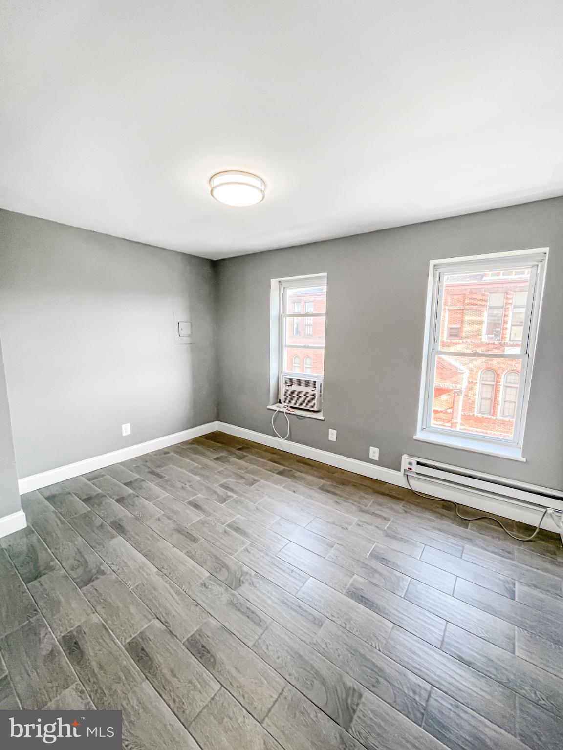 1434 Light Street Baltimore, MD 21230 - Photo 13 of 20 an empty room with wooden floor and windows