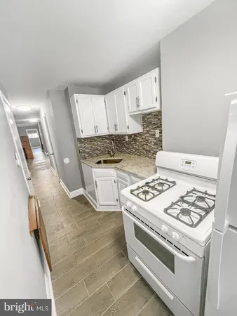 a white stove top oven sitting inside of a kitchen