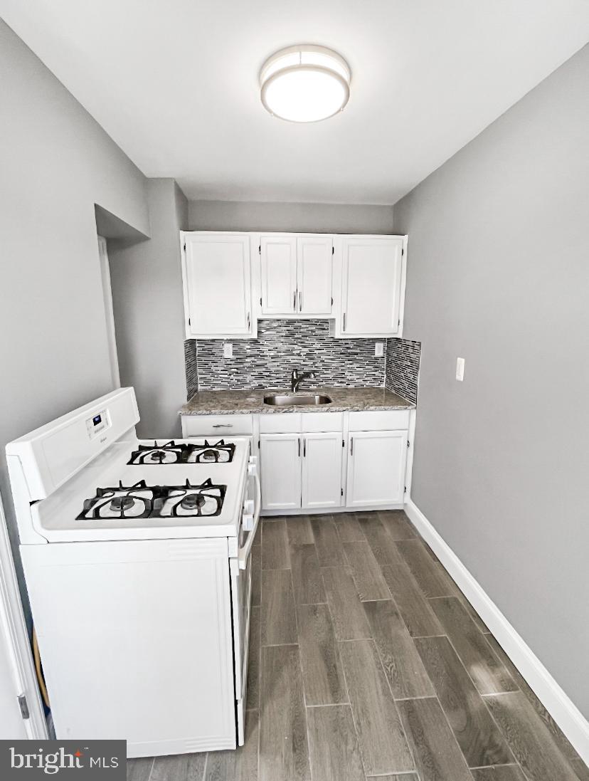 1434 Light Street Baltimore, MD 21230 - Photo 10 of 20 a kitchen with granite countertop a sink a stove and cabinets