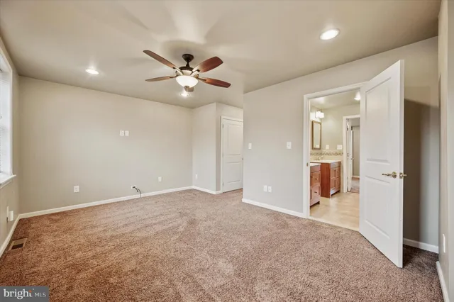 an empty room with fan and entrance