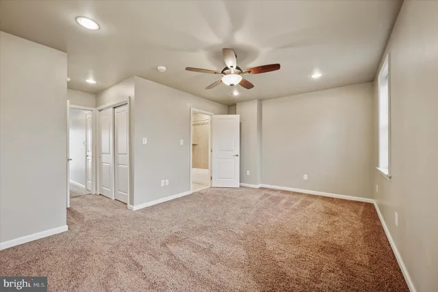 a view of an empty room with a ceiling fan