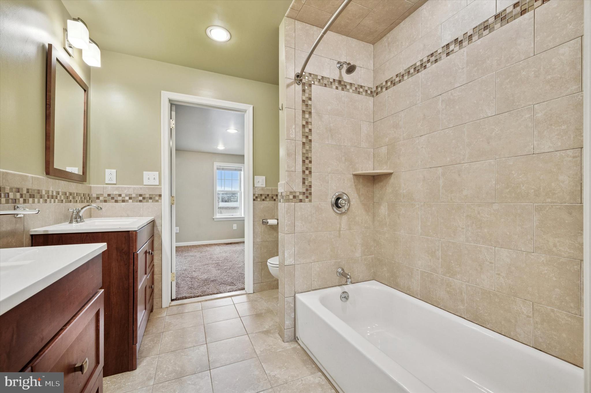 2351 East York Street Philadelphia, PA 19125 - Photo 35 of 44 a bathroom with a bathtub a sink a vanity and a shower