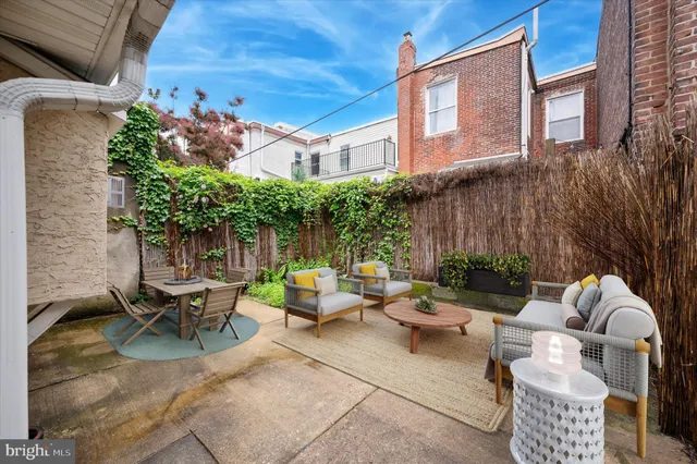 a view of a patio with couches table and chairs and potted plants