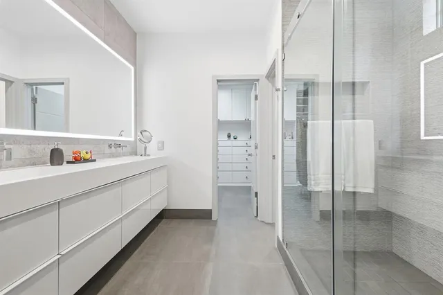 a spacious bathroom with a shower sink and a mirror