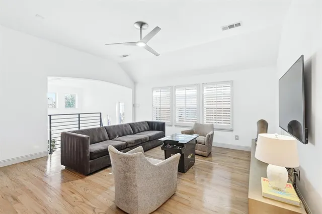 a living room with furniture wooden floor and a large window