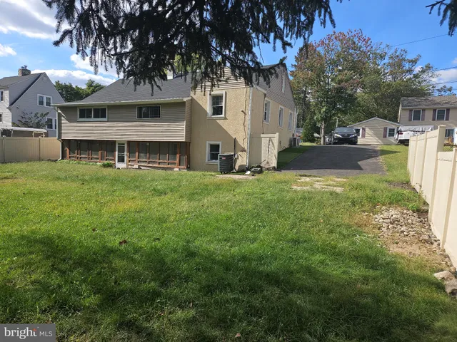 a view of a white house with a big yard and large trees