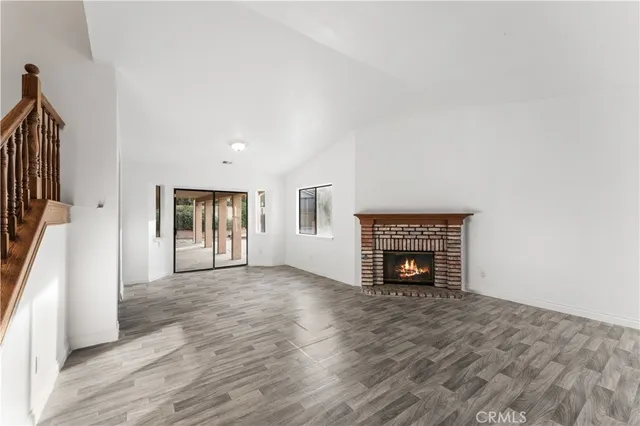 a view of a livingroom with wooden floor and stairs