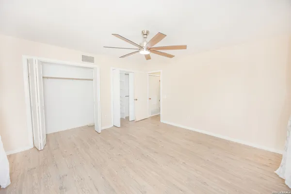 an empty room with closet and a ceiling fan