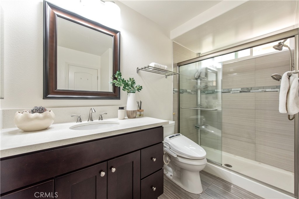 19933 Hidden Springs Road Walnut, CA 91789 - Photo 12 of 26 a bathroom with a granite countertop sink toilet a mirror and shower