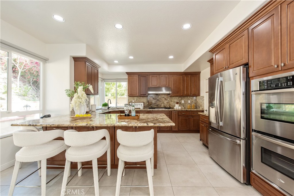 19933 Hidden Springs Road Walnut, CA 91789 - Photo 8 of 26 a kitchen with refrigerator a sink and chairs