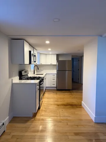a kitchen with stainless steel appliances granite countertop a refrigerator and a stove top oven