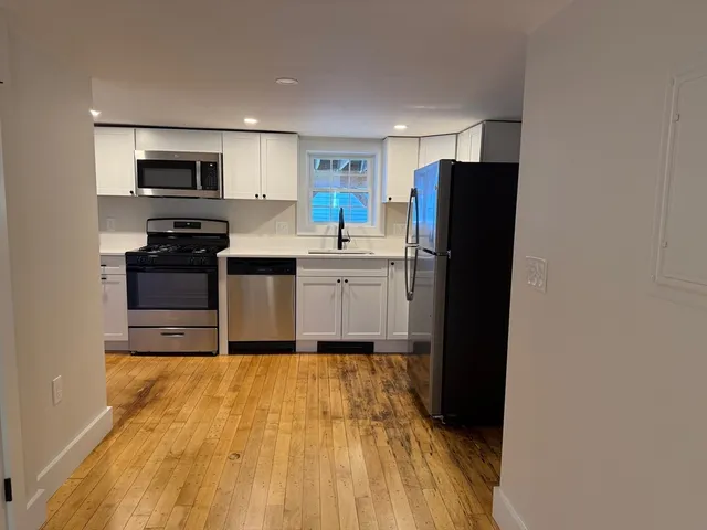 a kitchen with a refrigerator and a stove top oven
