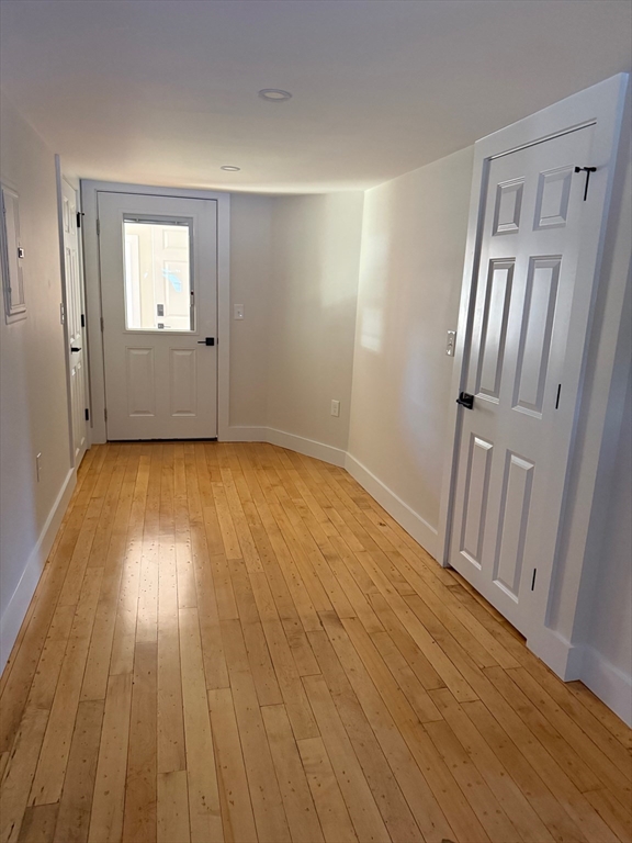 244 Main Street, Unit 1 North Andover, MA 01845 - Photo 9 of 13 a view of an empty room with wooden floor and a window