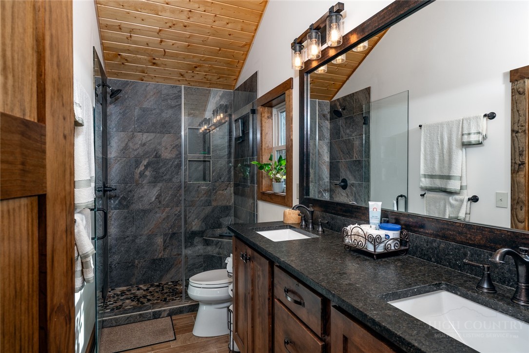 1161 Grandview Dr Extension Boone, NC 28607 - Photo 18 of 43 a bathroom with a granite countertop sink a toilet a mirror and shower