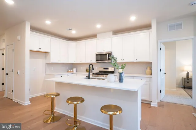 a kitchen with stainless steel appliances granite countertop a sink refrigerator and cabinets