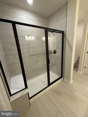 a spacious bathroom with a double vanity sink a mirror and a shower