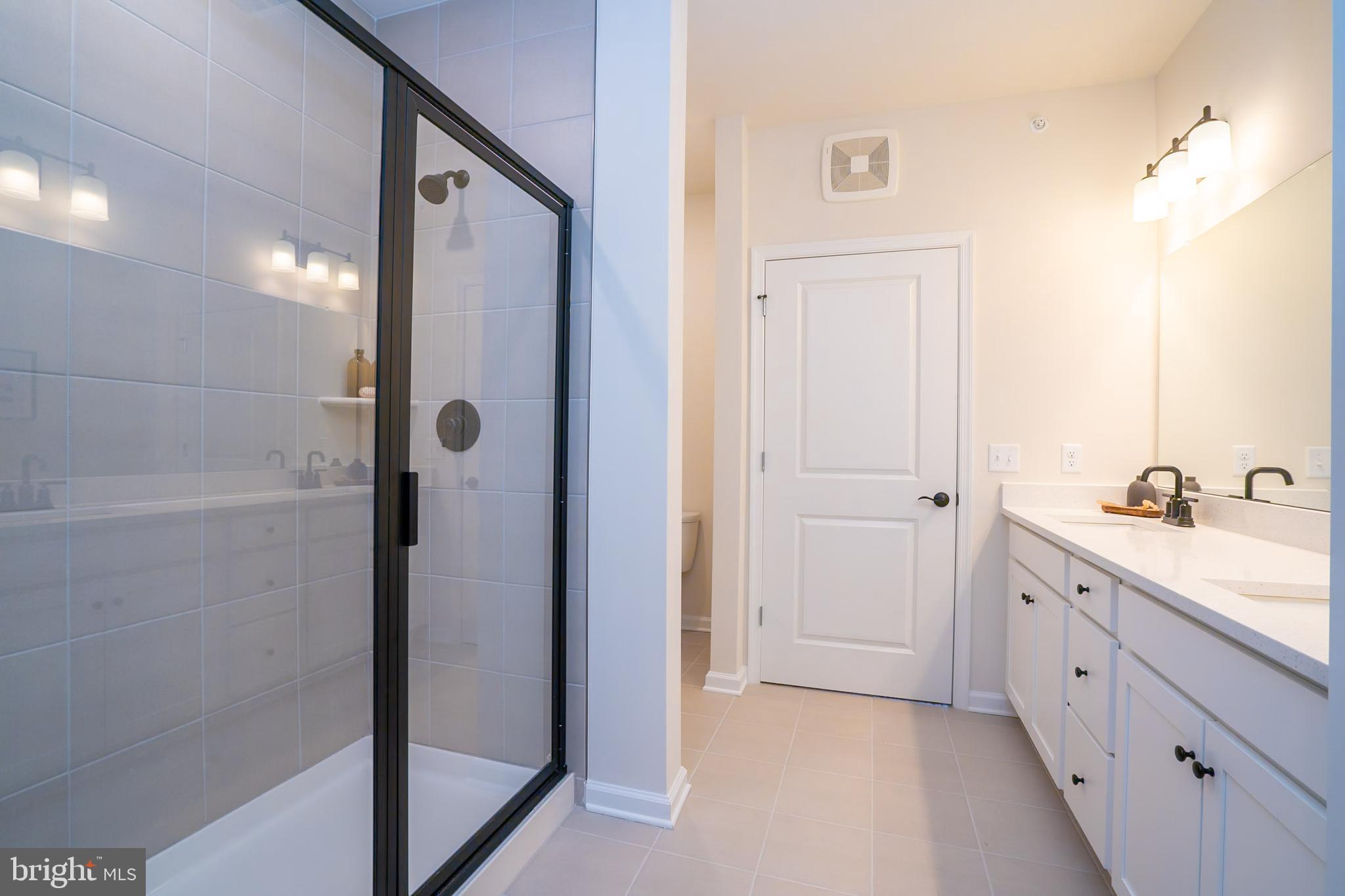 1 Culvert Drive, Unit 312 Princeton Junction, NJ 08540 - Photo 37 of 58 a spacious bathroom with a double vanity sink a mirror and a shower