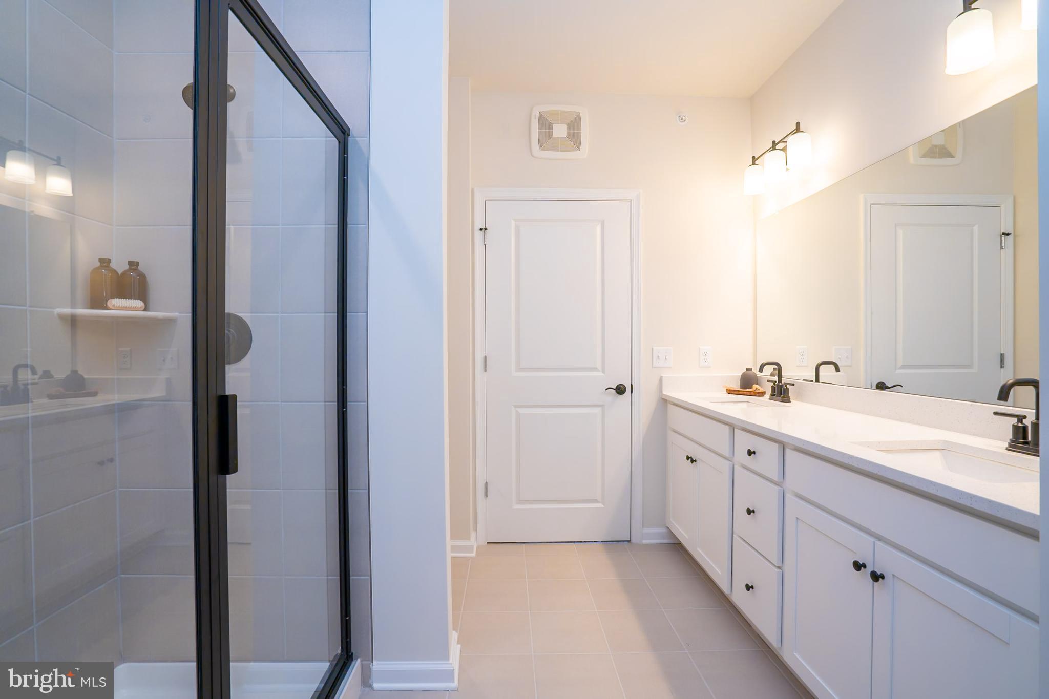 1 Culvert Drive, Unit 312 Princeton Junction, NJ 08540 - Photo 38 of 58 a spacious bathroom with a double vanity sink a mirror and a shower