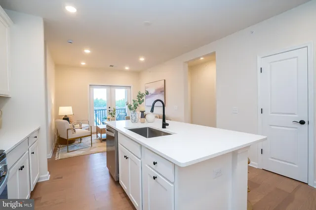 a kitchen with kitchen island granite countertop wooden cabinets a stove a sink and a refrigerator