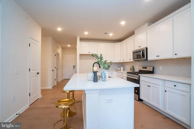 a kitchen with white cabinets appliances and a sink