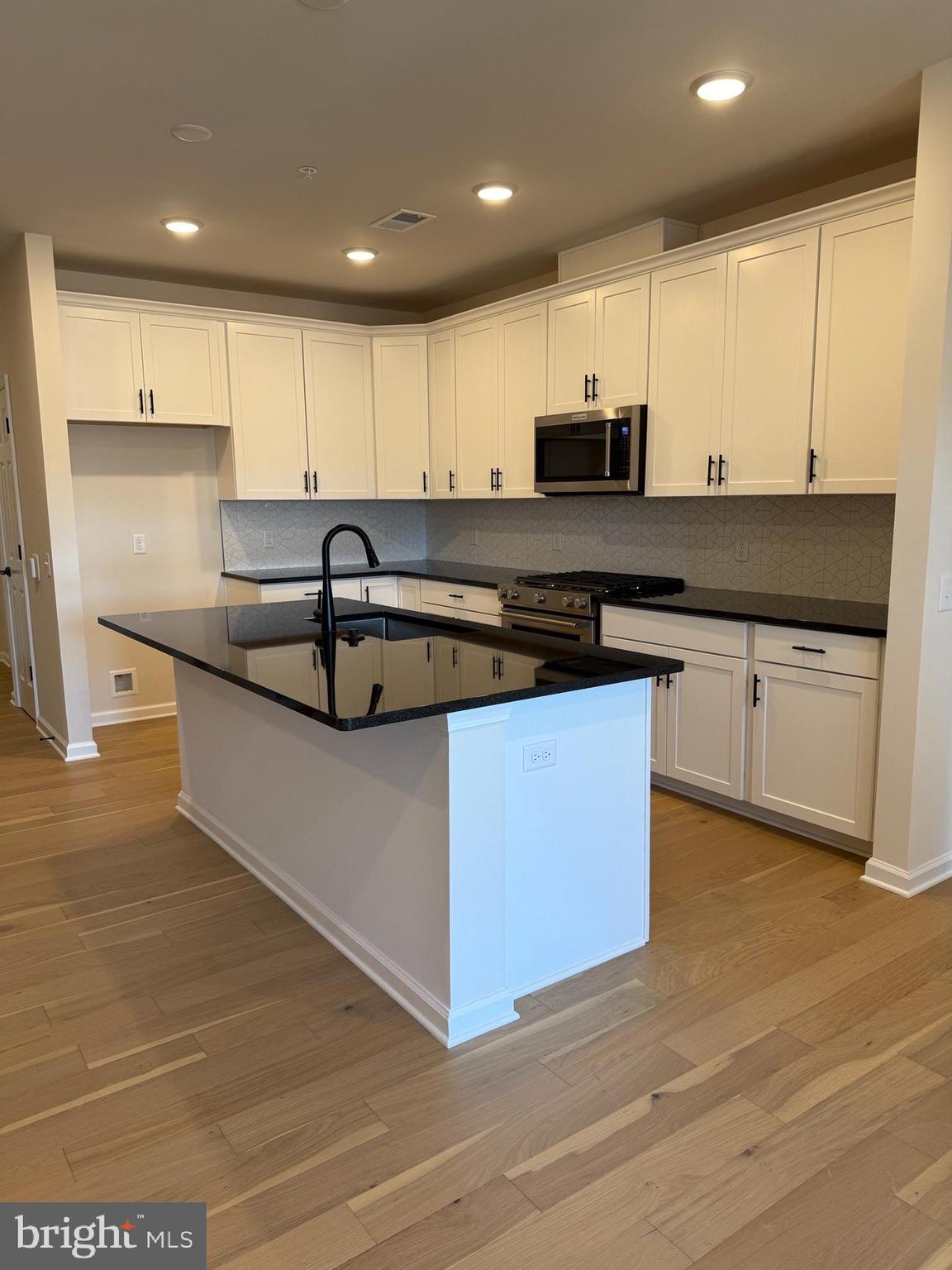 1 Culvert Drive, Unit 312 Princeton Junction, NJ 08540 - Photo 7 of 58 a kitchen with stainless steel appliances granite countertop a stove a sink and a microwave