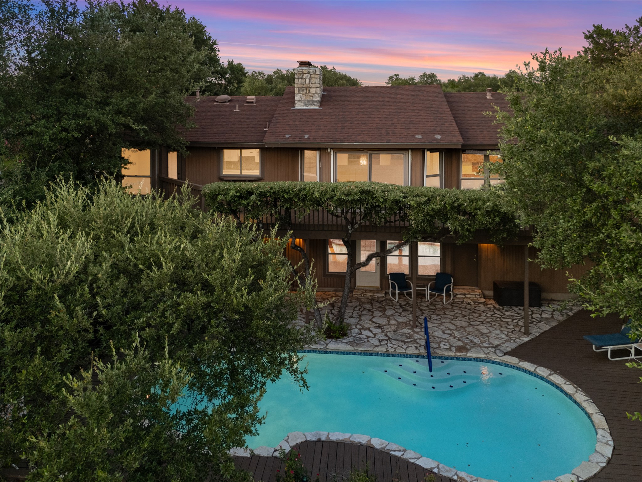 5319 Musket Ridge Austin, TX 78759 - Photo 38 of 39 An inviting pool and patio area await below a multi-level residence with natural surroundings.