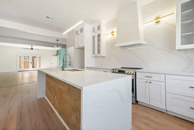a kitchen with a sink a stove and cabinets