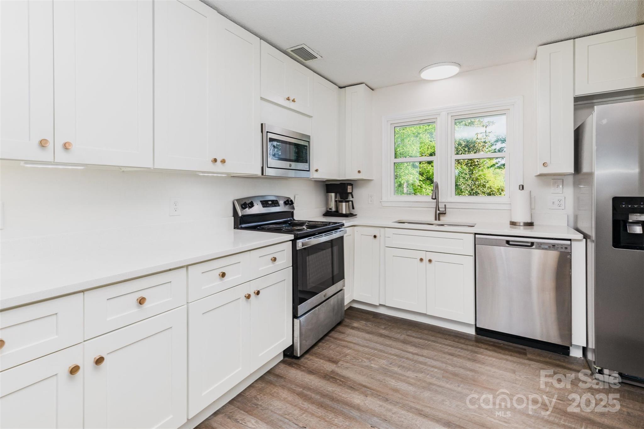 1041 Brawley School Road Mooresville, NC 28117 - Photo 10 of 19 a kitchen with white cabinets white appliances and sink