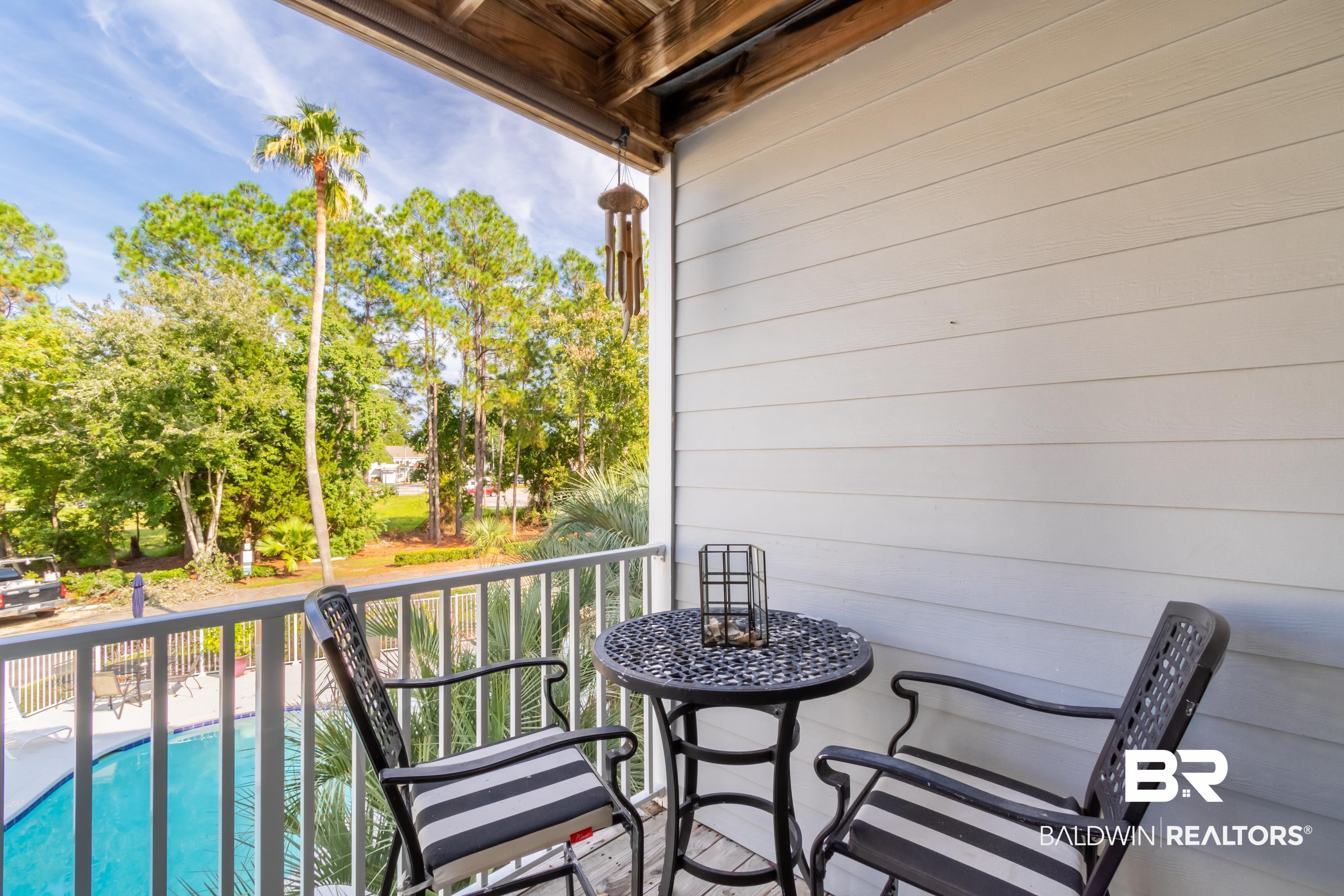 25957 Canal Road, Unit 208 Orange Beach, AL 36561 - Photo 11 of 28 Balcony featuring white vertical railings, a wood-paneled ceiling, and light-colored horizontal siding