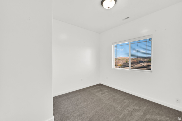 8215 Clear Rock Road, Unit 12 Eagle Mountain, UT 84005 - Photo 14 of 38 Bright interior room featuring a large window with horizontal blinds, neutral carpet flooring, and white walls