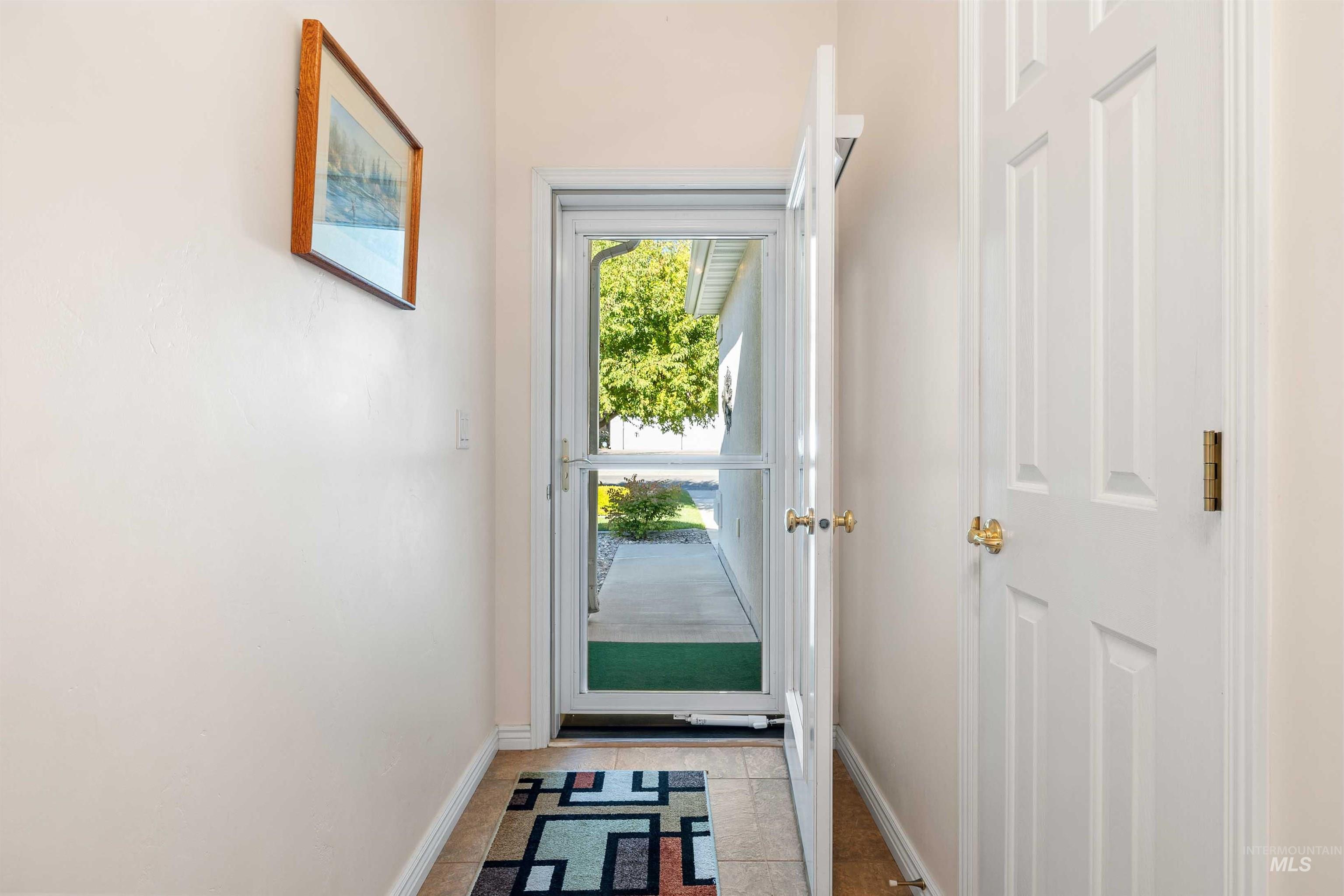 215 Los Lagos Twin Falls, ID 83301 - Photo 3 of 30 Doorway to outside with tile patterned flooring and baseboards