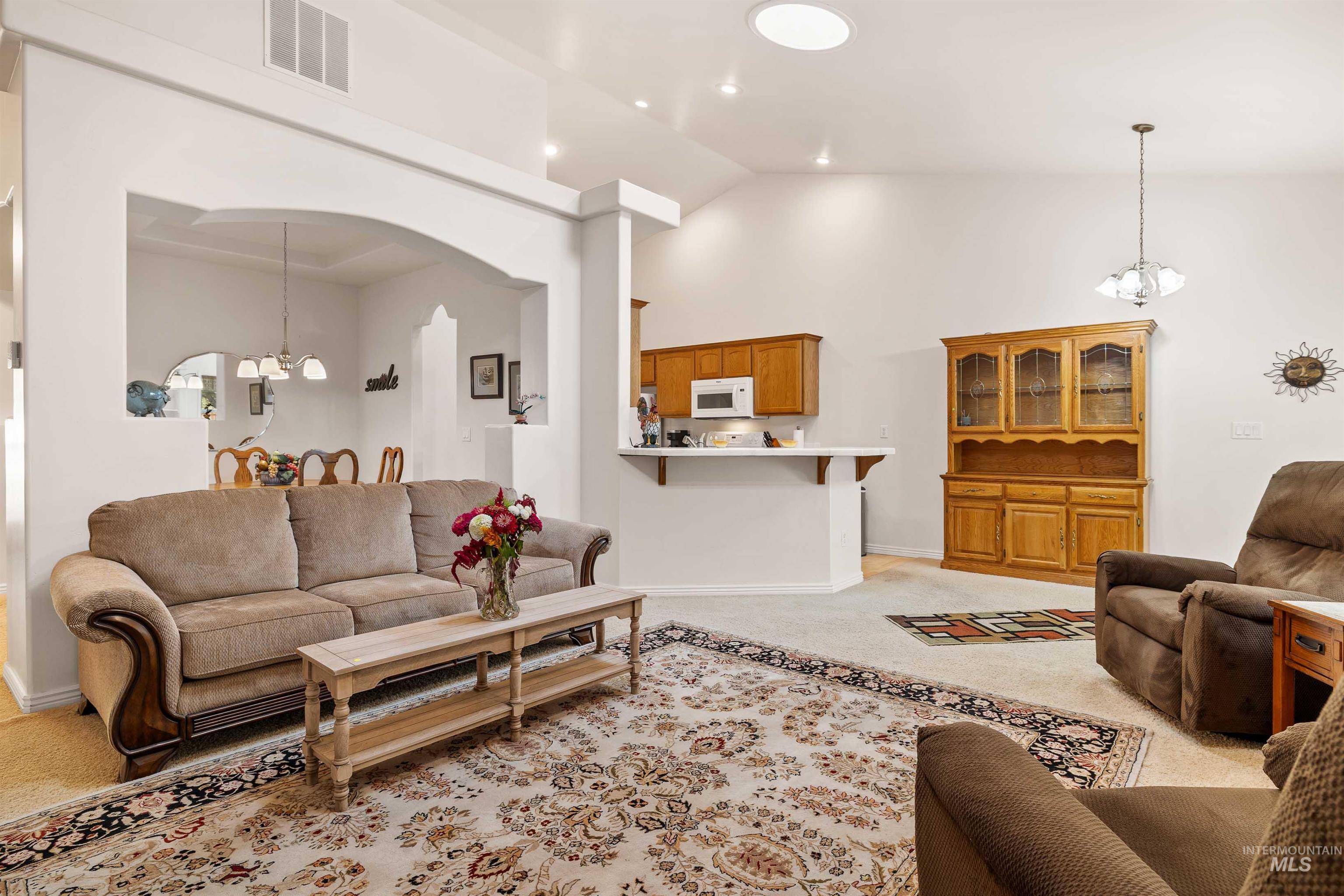 215 Los Lagos Twin Falls, ID 83301 - Photo 8 of 30 Living area featuring a chandelier, light colored carpet, high vaulted ceiling, arched walkways, and recessed lighting