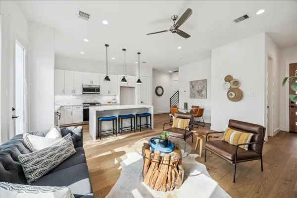 a kitchen with stainless steel appliances kitchen island a table chairs and a refrigerator