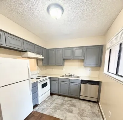 a kitchen with stainless steel appliances a refrigerator sink and cabinets