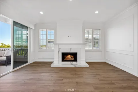 an empty room with windows and fireplace