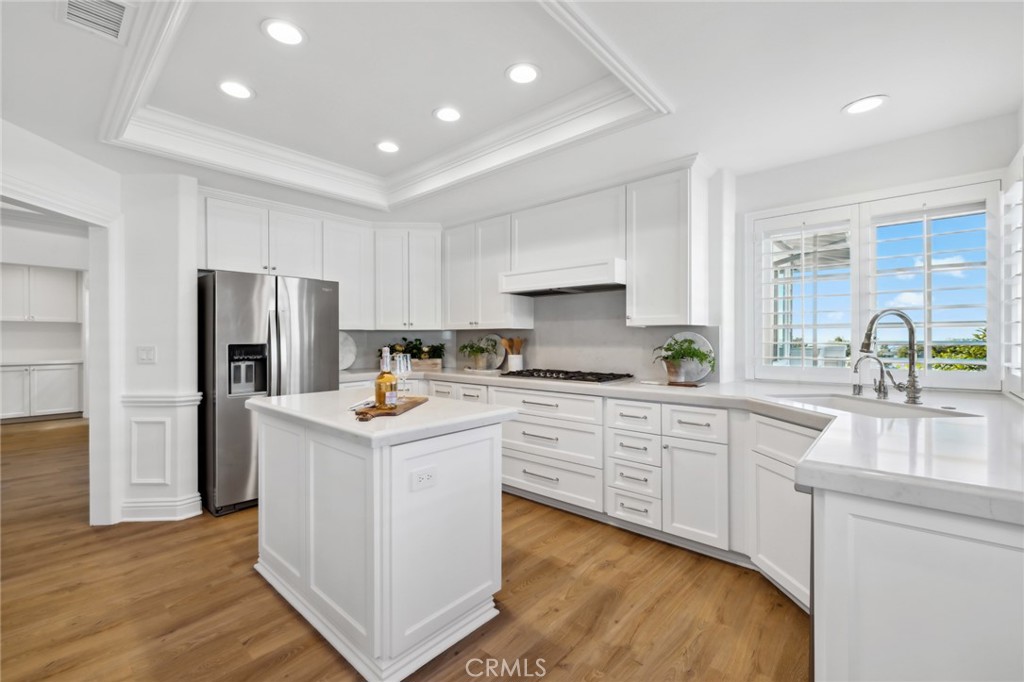 3521 Geranium Avenue, Unit 22 Corona del Mar, CA 92625 - Photo 14 of 37 a kitchen that has a lot of white cabinets and stainless steel appliances