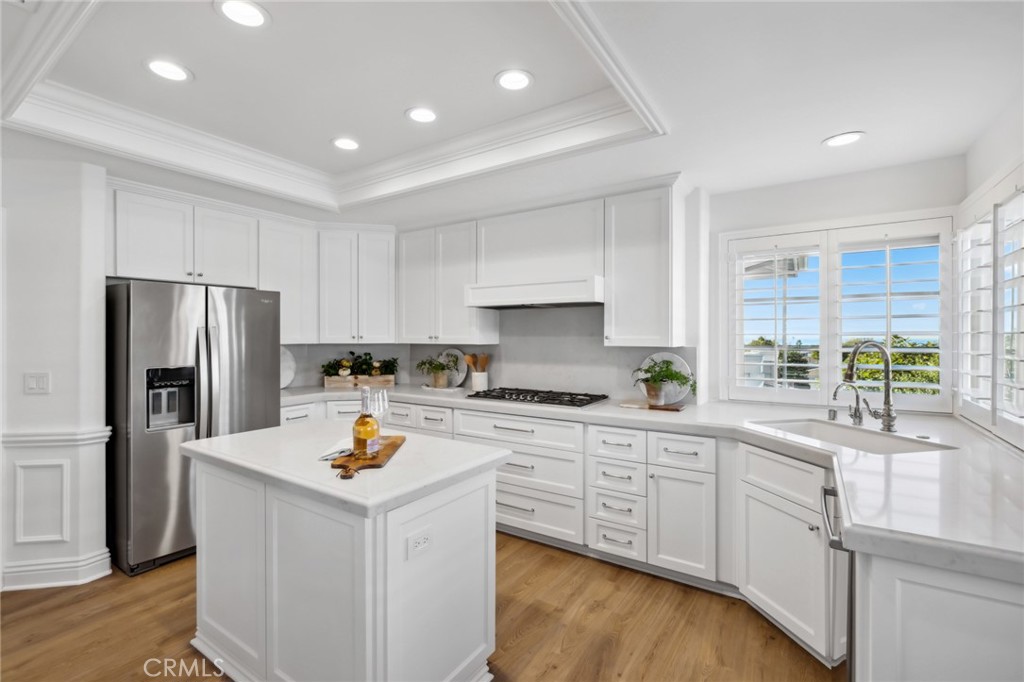 3521 Geranium Avenue, Unit 22 Corona del Mar, CA 92625 - Photo 15 of 37 a kitchen with white cabinets and stainless steel appliances