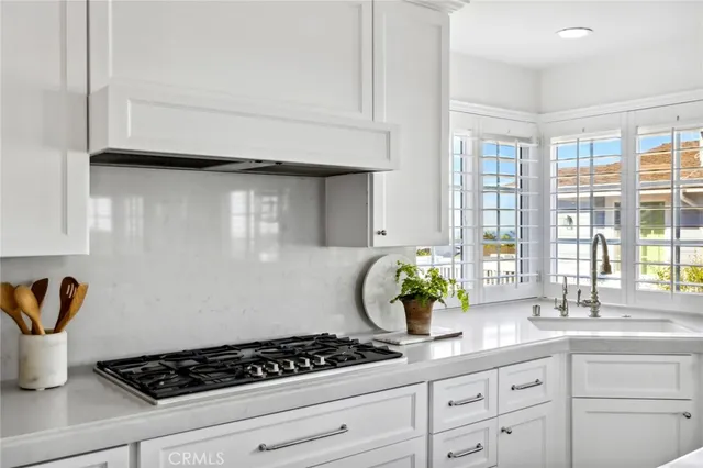 a kitchen with a stove and white cabinets