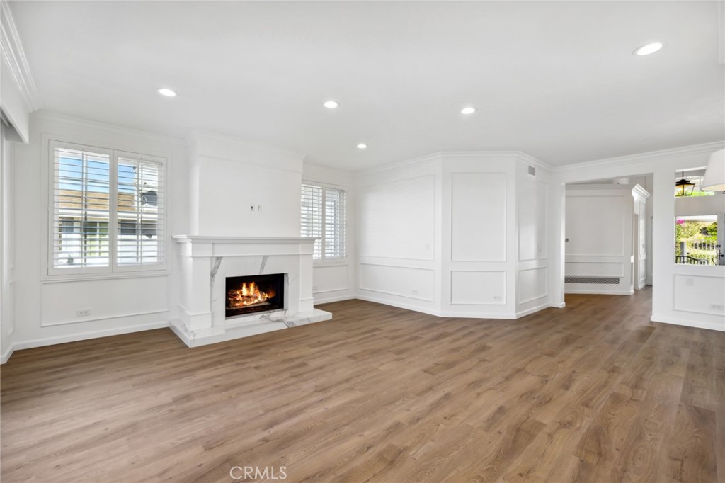 3521 Geranium Avenue, Unit 22 Corona del Mar, CA 92625 - Photo 18 of 37 an empty room with wooden floor fireplace and windows