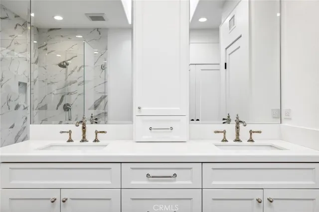 a bathroom with double vanity sink and a mirror